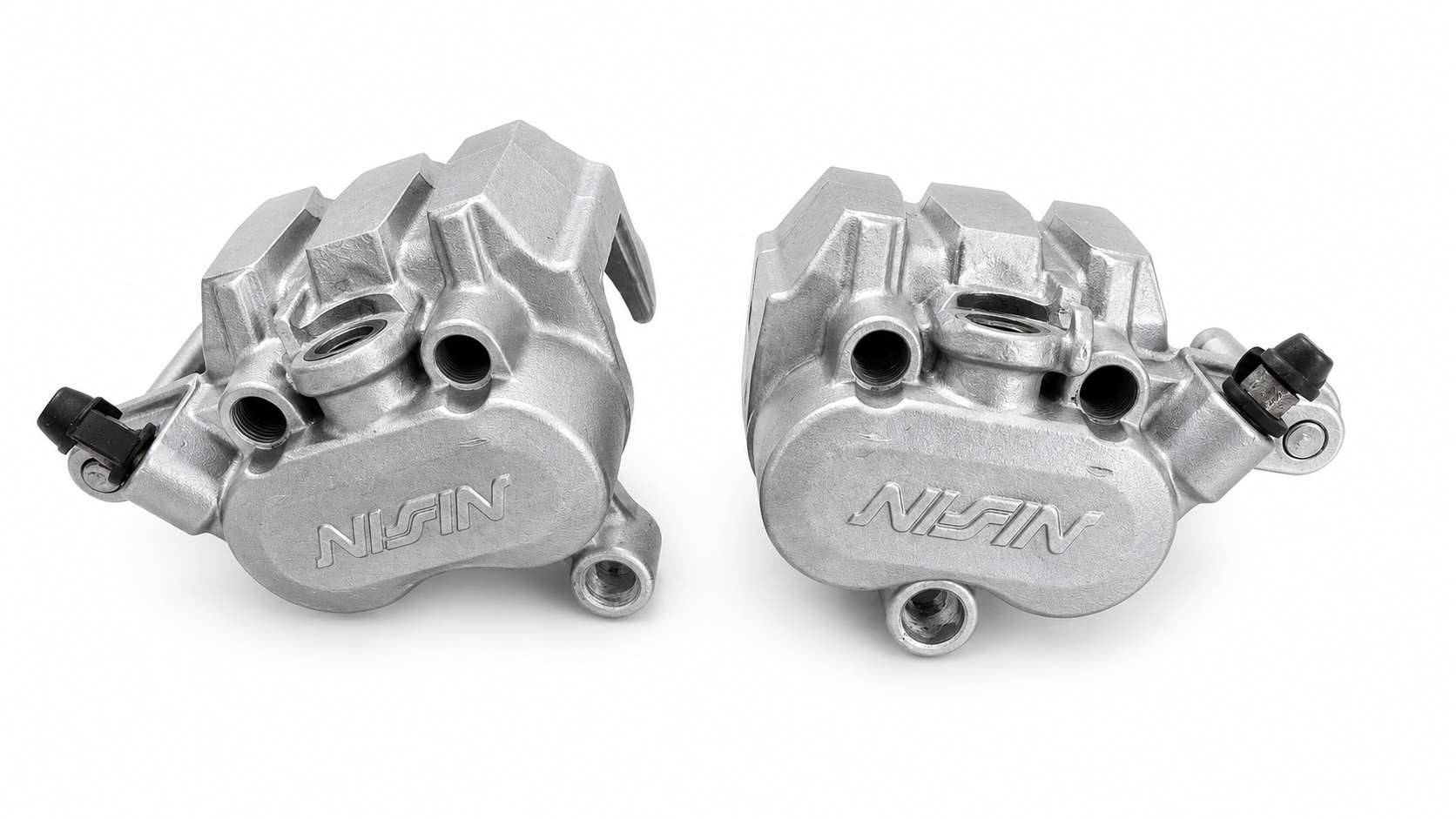 Pair of Nissin motorcycle brake calipers restored to a clean satin aluminium finish by vapour blasting